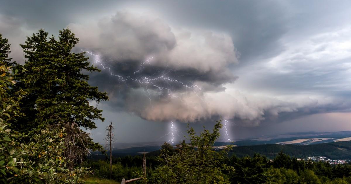 Storm clouds and lightning can be seen in the distance