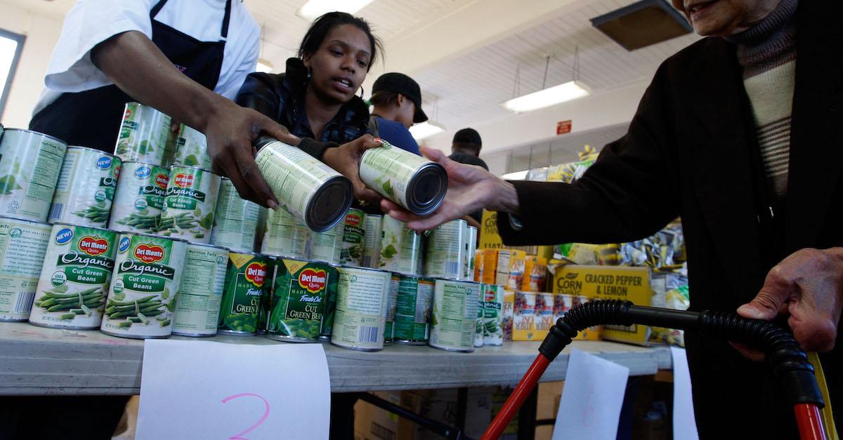 People pass cans of vegetables across a table